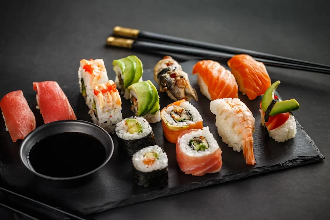 Ein elegant angerichteter Teller mit einer Auswahl an bunten, kunstvollen Special Rolls von Itoshii, im Vordergrund scharf, der Hintergrund leicht unscharf mit dem dezenten Ambiente des Restaurants.